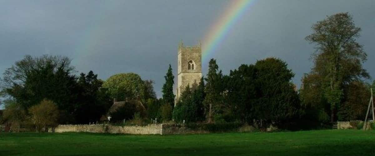 A church tower with a rainbow in the background.