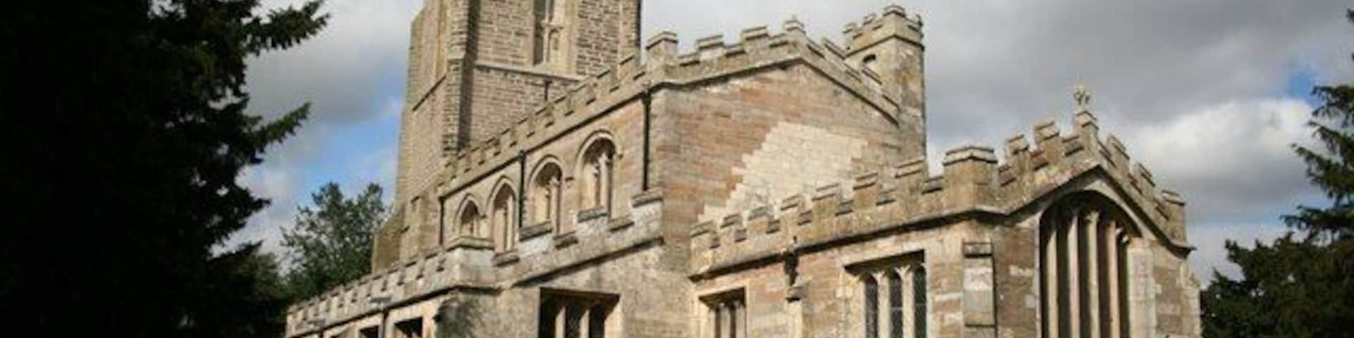Una iglesia histórica con una torre alta y ventanas de arco.