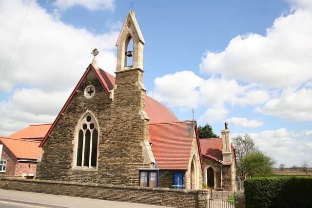 A stone church with a red roof and a bell tower.