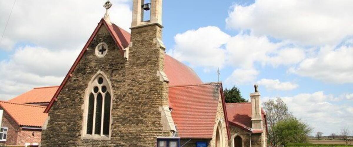 A stone church with a red roof and a bell tower.