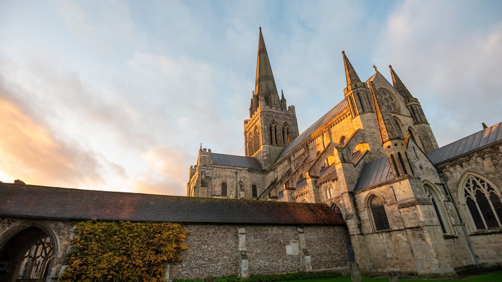 A historic church with a tall spire and a large rose window.