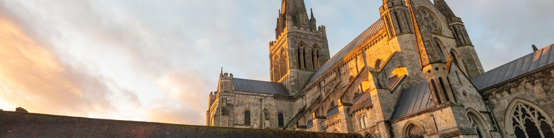 A historic church with a tall spire and a large rose window.