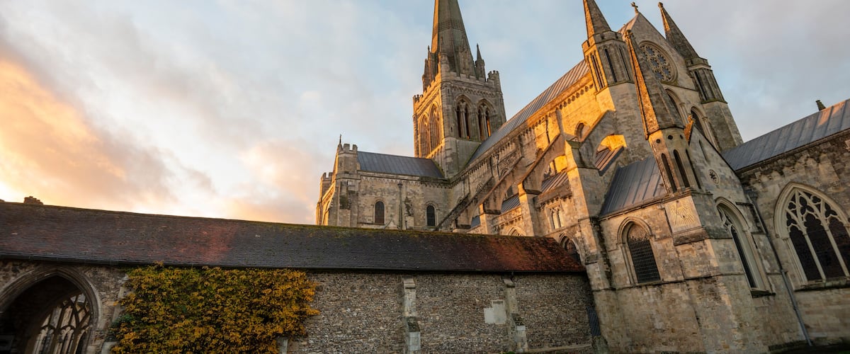 A historic church with a tall spire and a large rose window.