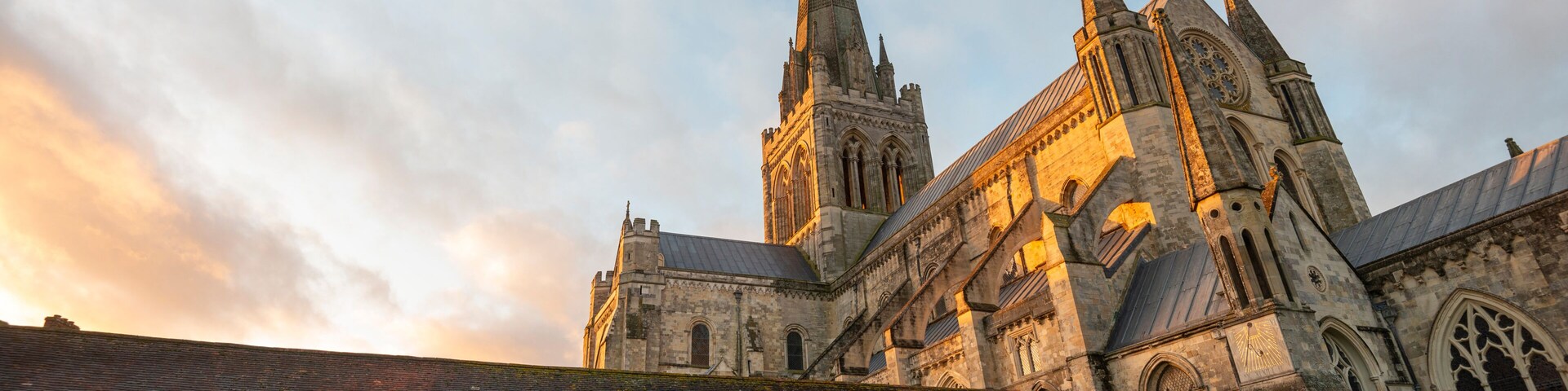 A historic church with a tall spire and a large rose window.