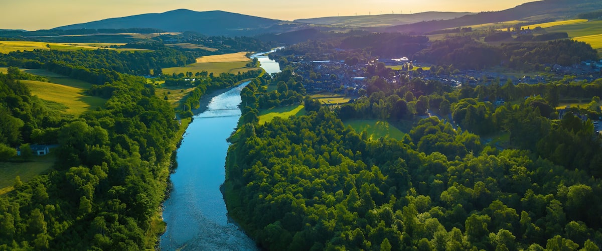 Aerial view of lush forest and meandering River Spey, Moray, Scotland.