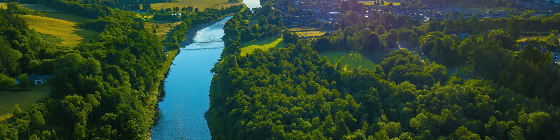 Aerial view of lush forest and meandering River Spey, Moray, Scotland.