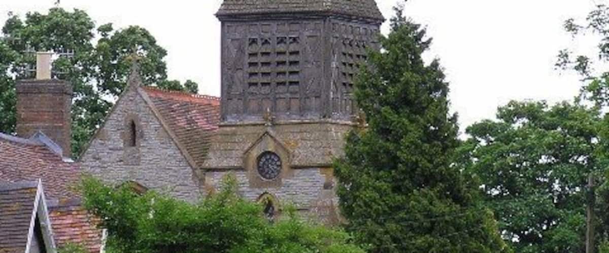 A church with a tall, pointed steeple and a clock tower.