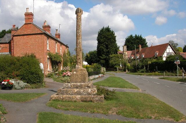 15th-century stone cross in Ashton-under-Hill, Worcestershire. The top of the cross has been lost, and has been replaced by a post-medieval sundial.