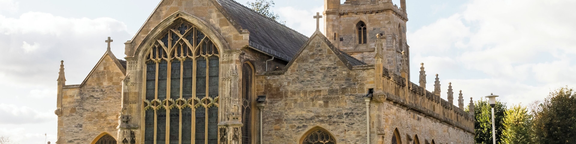 This is one of two parish churches in the precincts of Evesham Abbey. The original church on this site was first mentioned in 1195, and rebuilt about a hundred years later. The present church is from the late fifteenth century with an early sixteenth century south Chapel. After the Abbey's dissolution in 1540 the St Lawrence's fortune declined. It is now looked after by the Churches Conservation Trust, having been declared redundant in 1978. The church consists of a western tower with short spire, west doorway, clerestoried nave with four bay north and south aisles, chancel and chapel off the south aisle. The nave arcades are identical and extend into the chancel. There is no chancel arch. The south chapel is dedicated to Saint Clement and was built by Abbot Lichfield as his chantry around 1500. It has a carved fan vaulted roof with a central pendant. There was once a stone screen across the entrance. By the 18th C. the church had become very dilapidated. An extensive, but poor reconstruction took place in 1730, but by 1800 the roof had collapsed and the church was again unusable. In 1837 it was restored under Harvey Eginton who rebuilt the north side and replaced the roof. He also added a twin pulpit, reredos and reading desk. Further work in 1892 added stepped encaustic tiled floors and new seating. The church has a good selection stained glass windows by a variety of makers over a period of about 100 years. The octagonal font in the south aisle is mediaeval; there is also a replica in the Lichfield Chapel.
