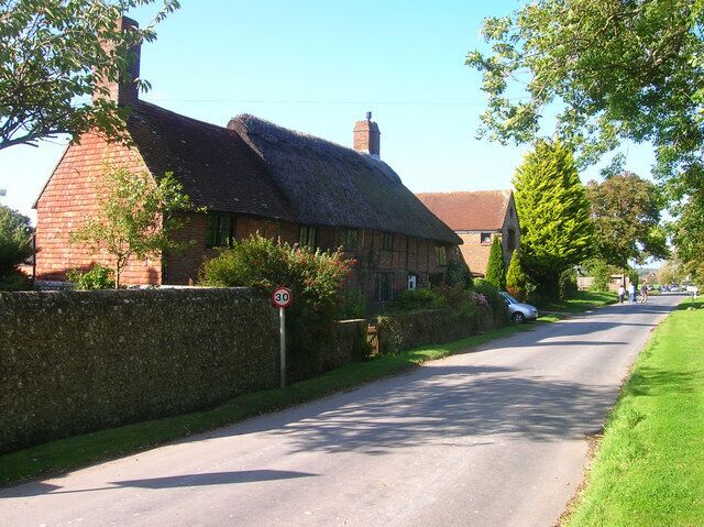 Pond Cottage, The Street The thatched part of the cottage seems to suggest a building from the 16th century. On the main village street as it heads towards the A27.