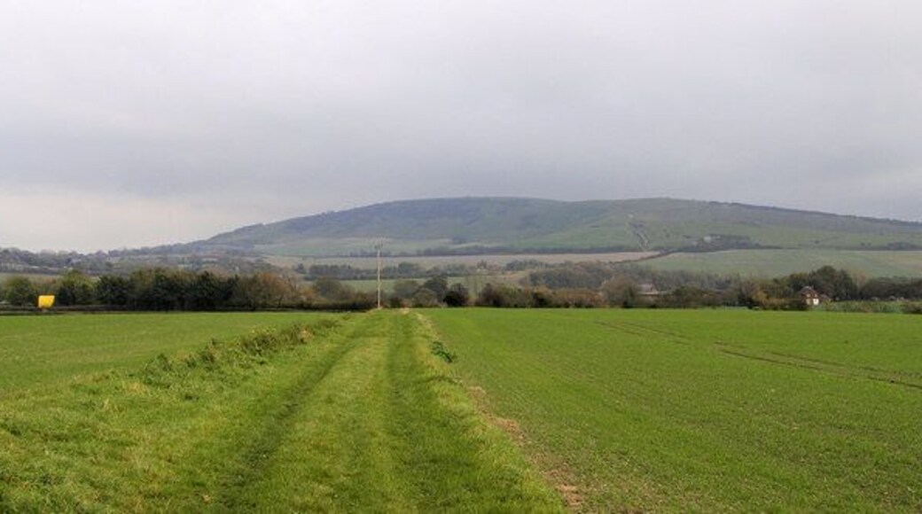 Footpath between Berwick and Alfriston Road Windover Hill in the distance - with the Long Man of Wilmington just out of view. The yellow object on the left is a bouncy castle at Drusilla's Zoo.
