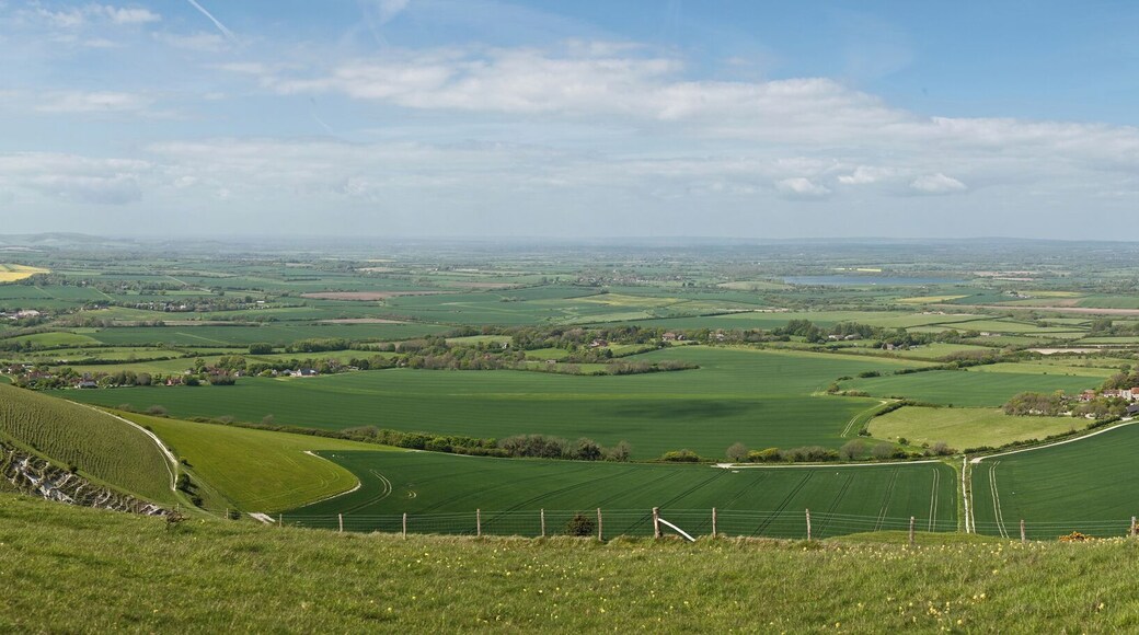 A panoramic wide view of the Long Man civil parish in East Sussex, England as viewed from just above the Long Man of Wilmington (at the bottom of the hill not visible). On the far left is the village of Milton Street, in the centre-right is the village of Wilmington, and in the distance on the far-right is Hailsham.