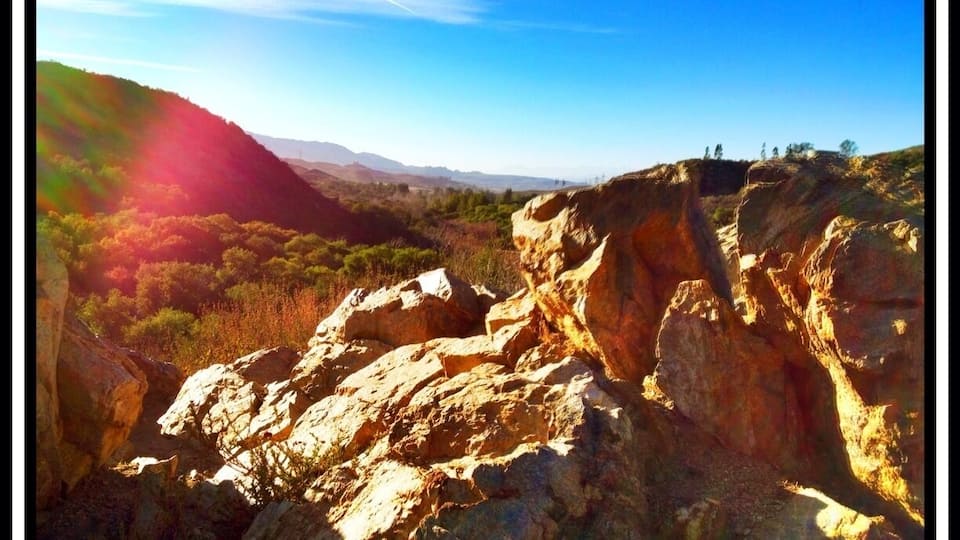 A mountainous landscape with rocky outcrops and a clear sky.