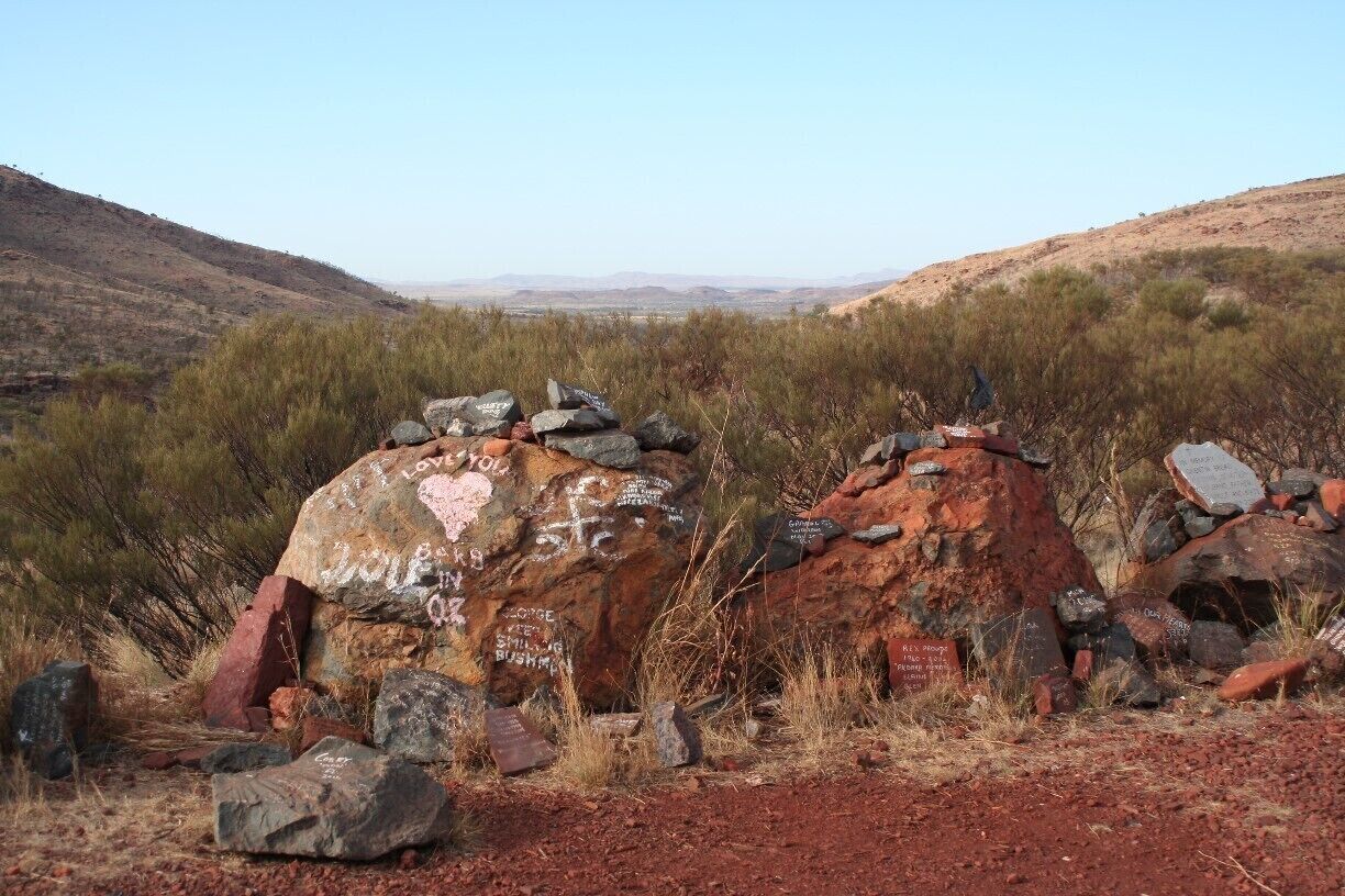 A desert landscape with large rocks and sparse vegetation.