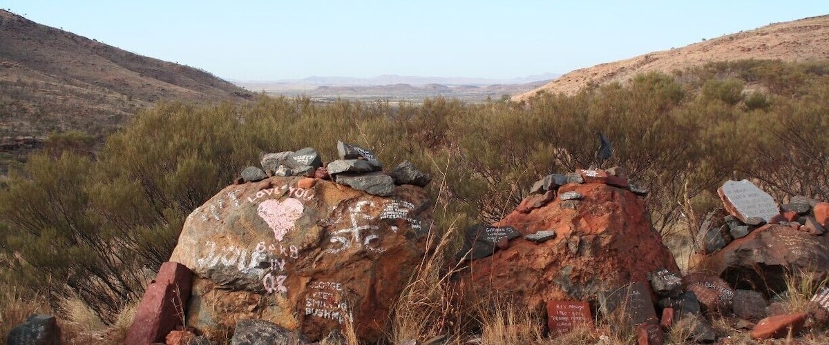 A desert landscape with large rocks and sparse vegetation.