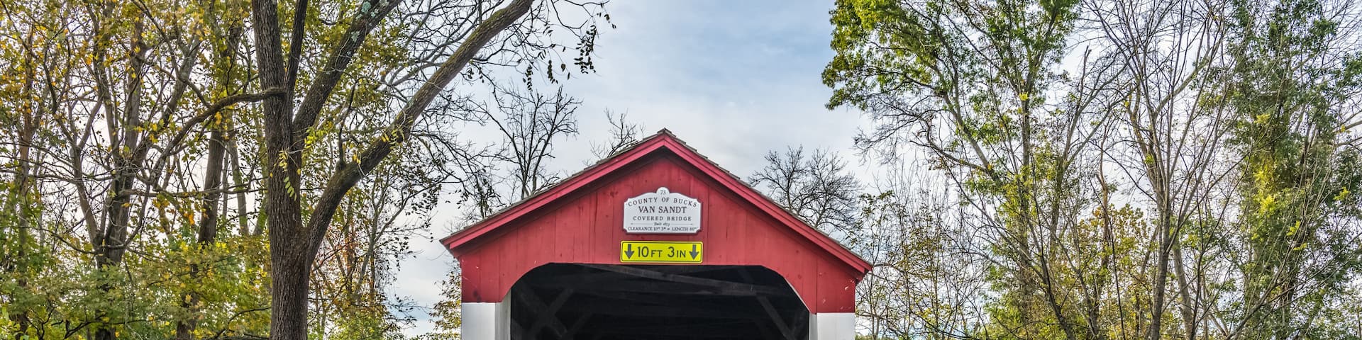 A covered bridge with a sign indicating it's the 73rd covered bridge in Van Sant County.
