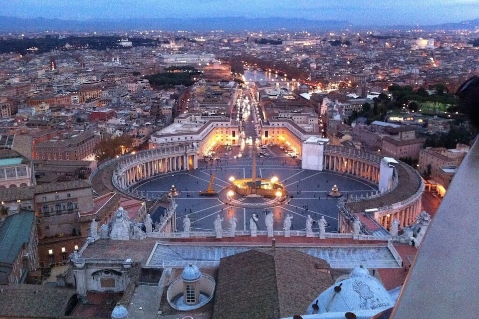 A panoramic view of a cityscape with a prominent circular plaza and a large building with a dome.