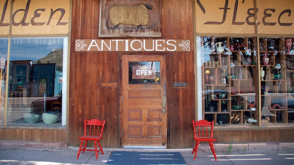 A wooden storefront with a sign reading "ANTIQUES" and a sheep decoration above the door.
