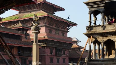 Statue of Malla King on top af o column, amongst Patan Durbar square temples in Kathmandu, Nepal