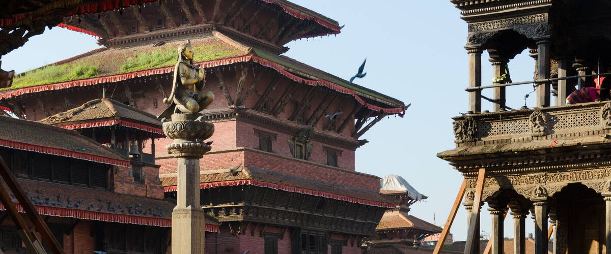 A traditional multi-tiered building with intricate carvings and a bell tower.