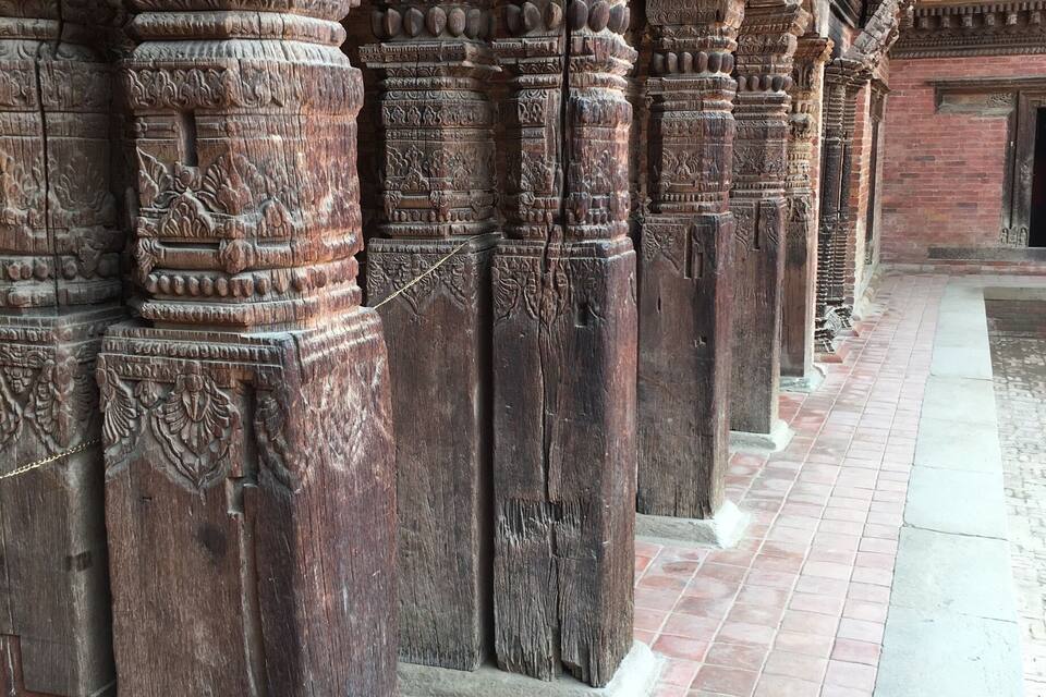 Intricately carved stone pillars and a tiled corridor.