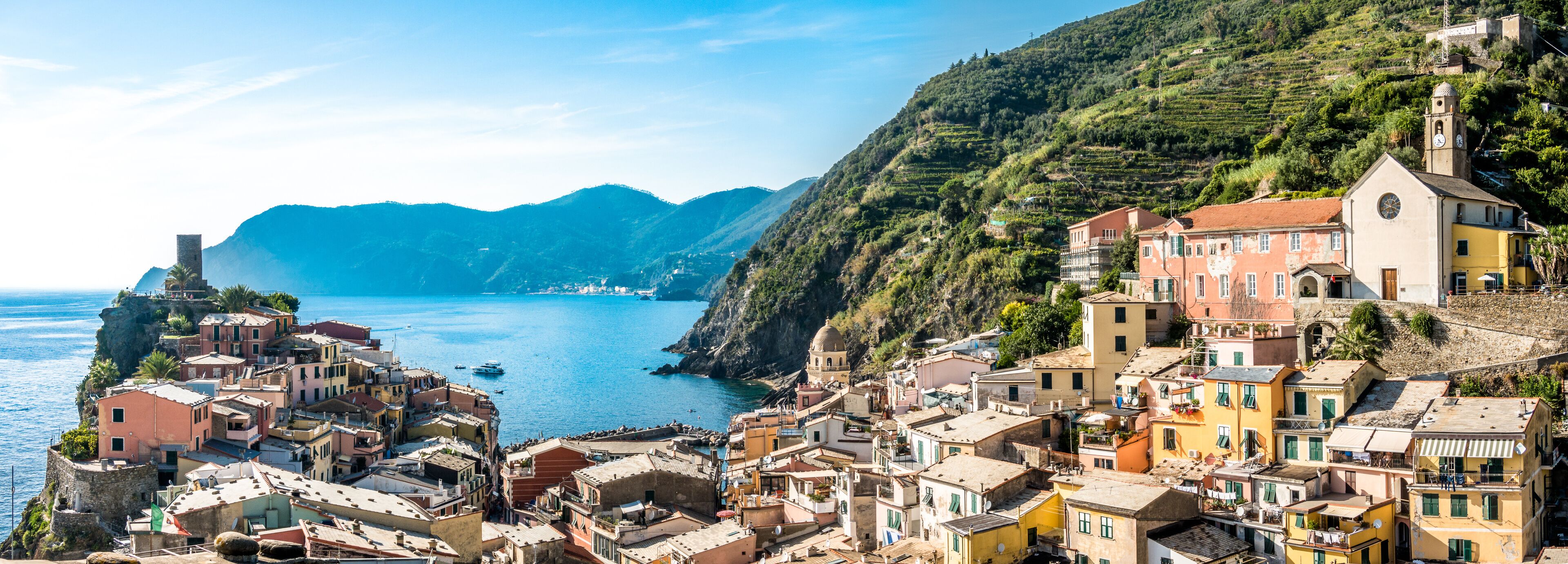 A coastal village with terraced houses, a church, and a sea view.