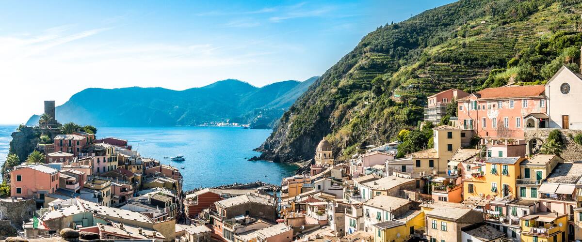 A coastal village with terraced houses, a church, and a sea view.