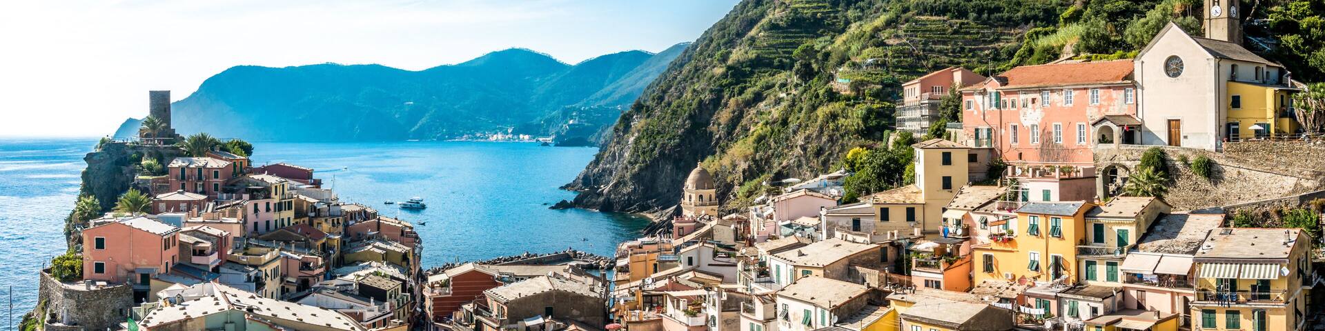 A coastal village with terraced houses, a church, and a sea view.