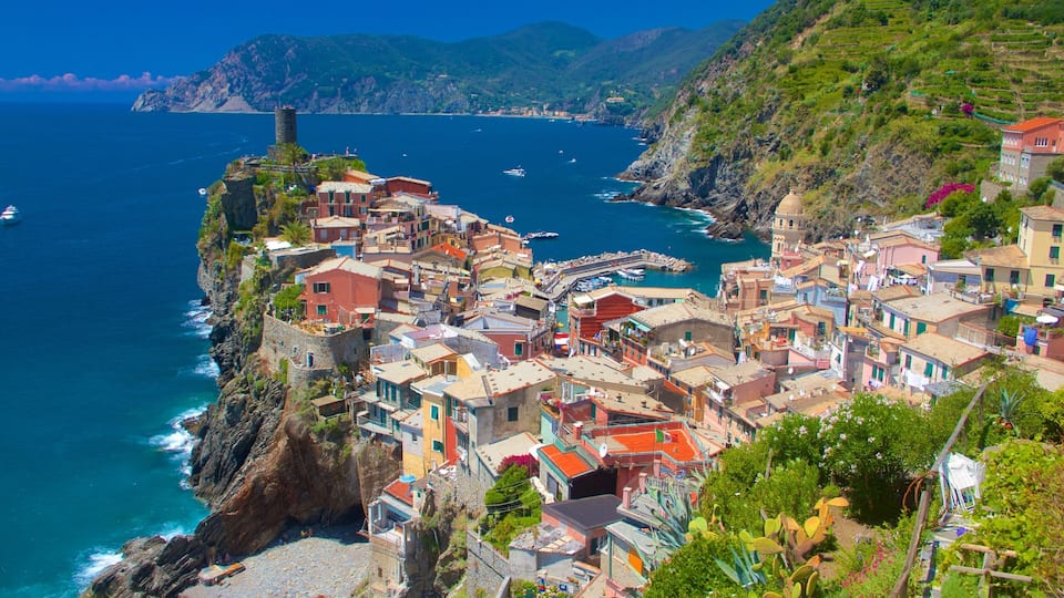 A coastal town with colorful buildings, a tower, and a rocky coastline.