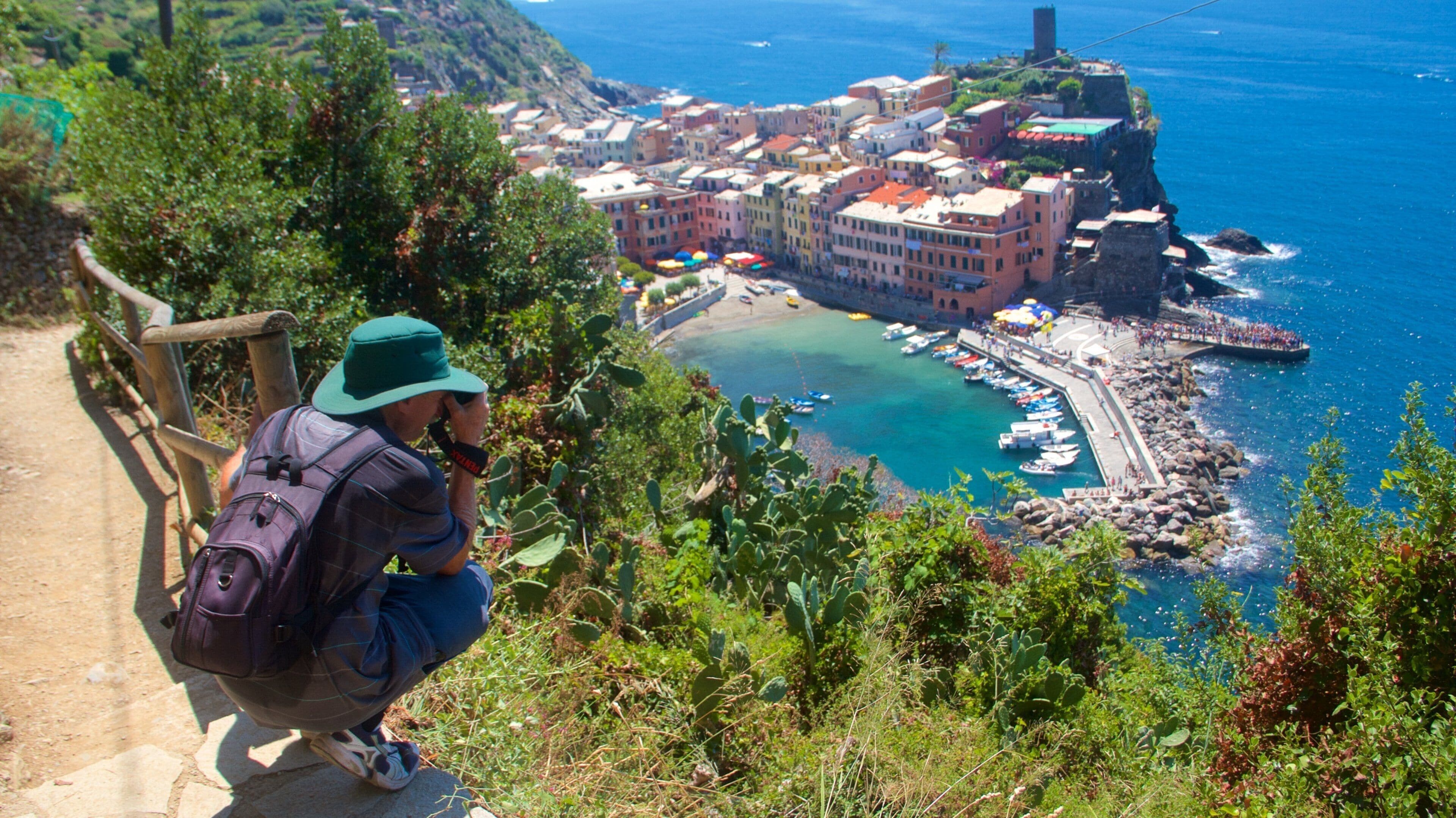 A coastal town with colorful buildings, a rocky shoreline, and a clear blue sea.