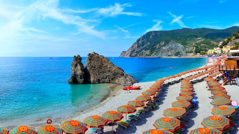 Panoramic view over colorful umbrellas at a beach in the Cinque Terre village of Monterosso