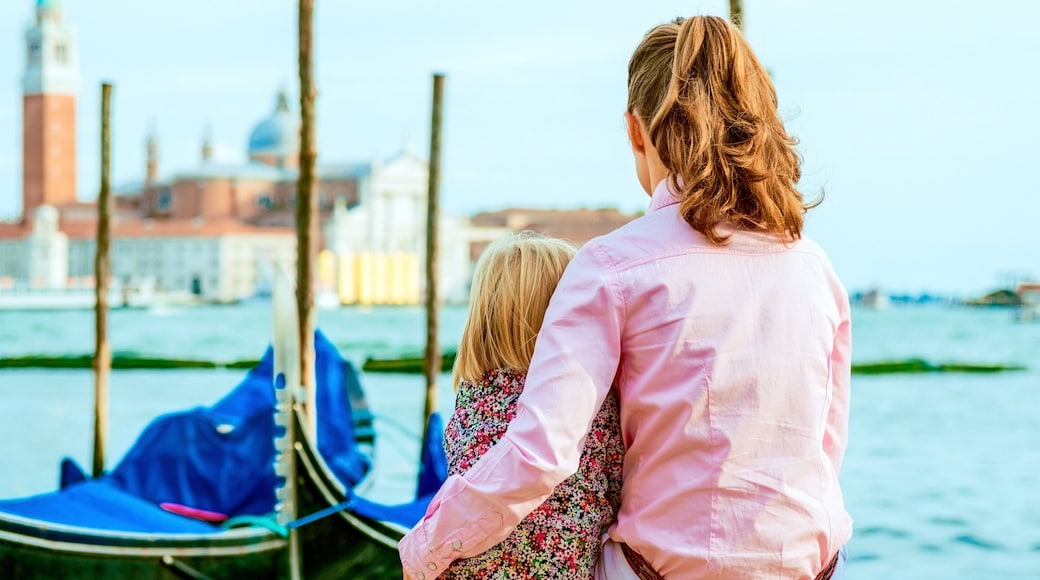 mother and baby sitting on grand canal embankment in