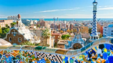 A panoramic view of a city with distinctive modern architecture, including a famous building with a mosaic roof and a tower with a checkered pattern.