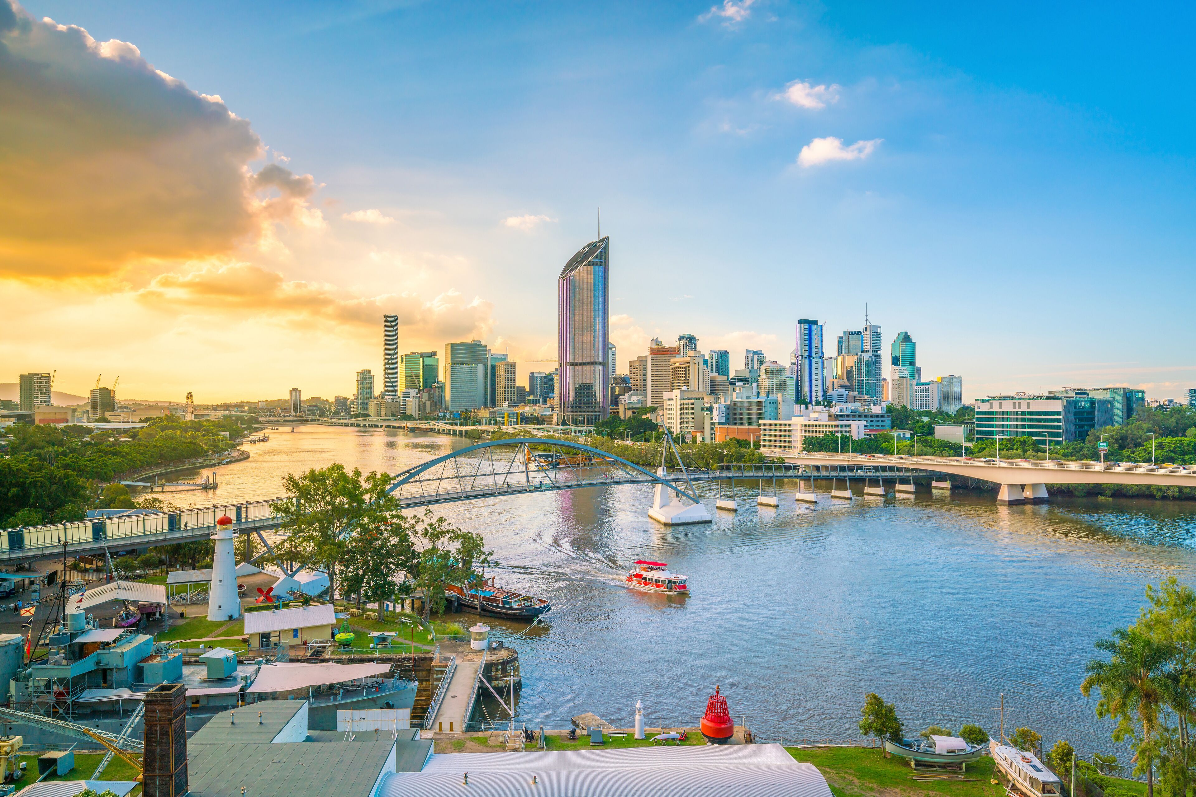 A city skyline with a river, a bridge, and a lighthouse.