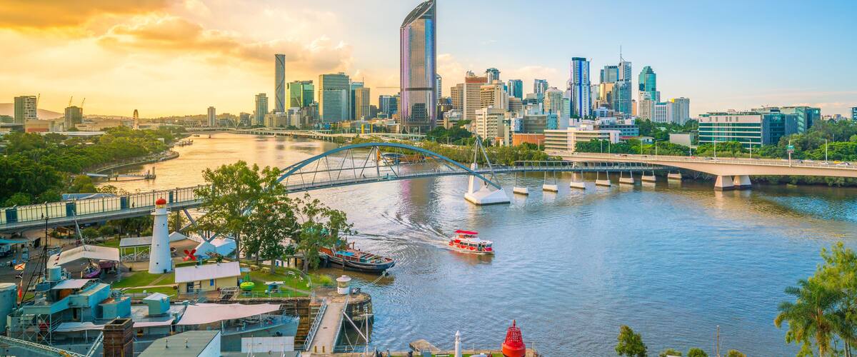 A city skyline with a river, a bridge, and a lighthouse.
