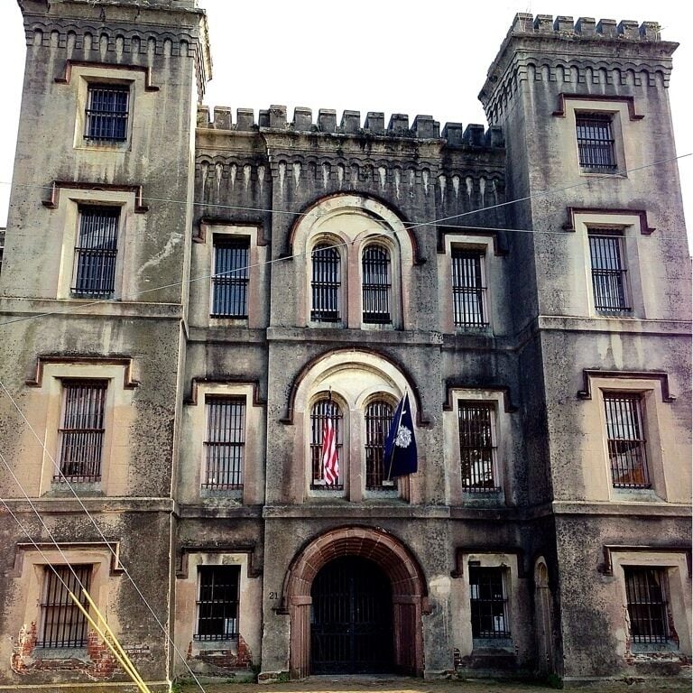 The Old City Jail stands as a haunting reminder of the city's darkest past. The jail, which was operational from 1802 until 1939, housed Charleston's most infamous criminals, 19th-century pirates and Civil War prisoners. The Old Jail building served as the Charleston County Jail from its construction in 1802 until 1939. In 1680, as the city of Charleston was being laid out, a four-acre square of land was set aside at this location for public use. In time a hospital, poor house, workhouse for runaway slaves, and this jail were built on the square. When the Jail was constructed in 1802 it consisted of four stories, topped with a two-story octagonal tower. 

Charleston architects Barbot & Seyle were responsible for 1855 alterations to the building, including a rear octagonal wing, expansions to the main building and the Romanesque Revival details. This octagonal wing replaced a fireproof wing with individual cells, designed by Robert Mills in 1822, five years earlier than his notable Fireproof Building. The 1886 earthquake badly damaged the tower and top story of the main building, and these were subsequently removed. The Old Jail housed a great variety of inmates. John and Lavinia Fisher, and other members of their gang, convicted of robbery and murder in the Charleston Neck region were imprisoned here in 1819 to 1820. 

Some of the last 19th-century high-sea pirates were jailed here in 1822 while they awaited hanging. The jail was active after the discovery of Denmark Vesey's planned slave revolt. In addition to several hundreds of free blacks and slaves jailed for their involvement, four white men convicted of supporting the 1822 plot were imprisoned here. Vesey spent his last days in the tower before being hanged. Increased restrictions were placed on slaves and free blacks in Charleston as a result of the Vesey plot, and law required that all black seaman be kept here while they were in port. During the Civil War, Confederate and Federal prisoners of war were incarcerated here.