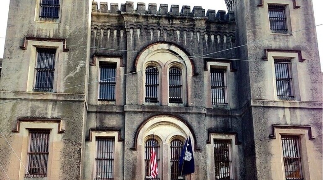 The Old City Jail stands as a haunting reminder of the city's darkest past. The jail, which was operational from 1802 until 1939, housed Charleston's most infamous criminals, 19th-century pirates and Civil War prisoners. The Old Jail building served as the Charleston County Jail from its construction in 1802 until 1939. In 1680, as the city of Charleston was being laid out, a four-acre square of land was set aside at this location for public use. In time a hospital, poor house, workhouse for runaway slaves, and this jail were built on the square. When the Jail was constructed in 1802 it consisted of four stories, topped with a two-story octagonal tower.
Charleston architects Barbot & Seyle were responsible for 1855 alterations to the building, including a rear octagonal wing, expansions to the main building and the Romanesque Revival details. This octagonal wing replaced a fireproof wing with individual cells, designed by Robert Mills in 1822, five years earlier than his notable Fireproof Building. The 1886 earthquake badly damaged the tower and top story of the main building, and these were subsequently removed. The Old Jail housed a great variety of inmates. John and Lavinia Fisher, and other members of their gang, convicted of robbery and murder in the Charleston Neck region were imprisoned here in 1819 to 1820.
Some of the last 19th-century high-sea pirates were jailed here in 1822 while they awaited hanging. The jail was active after the discovery of Denmark Vesey's planned slave revolt. In addition to several hundreds of free blacks and slaves jailed for their involvement, four white men convicted of supporting the 1822 plot were imprisoned here. Vesey spent his last days in the tower before being hanged. Increased restrictions were placed on slaves and free blacks in Charleston as a result of the Vesey plot, and law required that all black seaman be kept here while they were in port. During the Civil War, Confederate and Federal prisoners of war were incarcerated here.