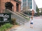 A brick building with a sign reading "Charleston Visitor Center" and a staircase leading up to it.