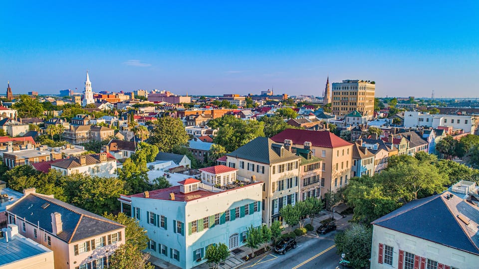 A coastal town with historic buildings, a prominent church steeple, and a clear blue sky.