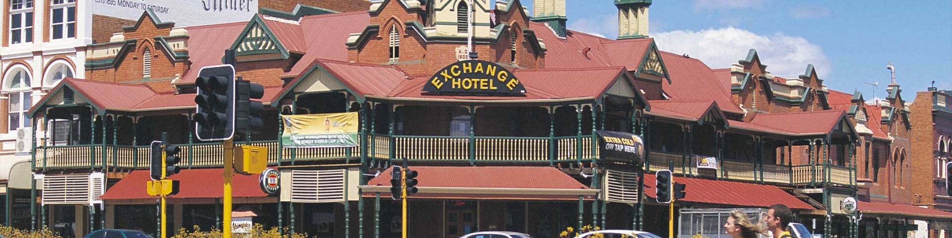 A historic building with a sign reading "Exchange Hotel" and a "Western Argus Offices" sign above it.