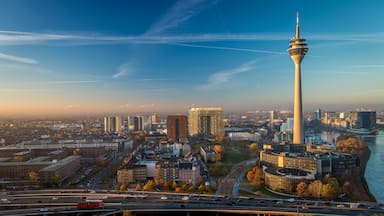 A cityscape with a prominent tower, a river, and a mix of modern and older buildings.
