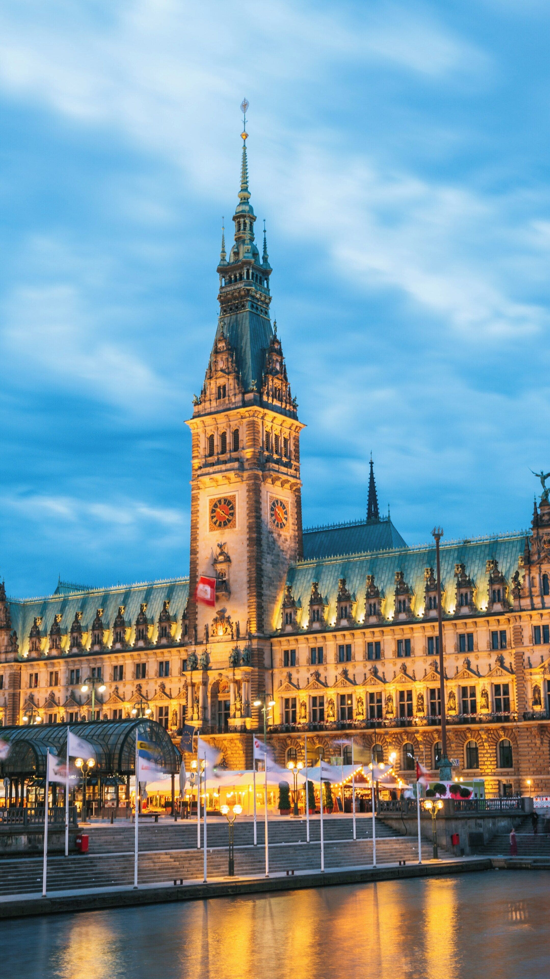 Majestic evening view of Hamburg City Hall illuminated against the twilight sky in Altstadt Hamburg, showcasing its architectural grandeur and historic charm