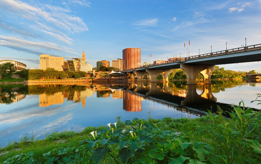 Beautiful sunrise over Connecticut River at Hartford Connecticut. Photo shows the skyline of Hartford, Founders Bridge and Bulkeley Bridge, which is the oldest highway bridges over Connecticut Rive