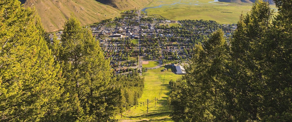 A town nestled in a valley with mountains in the background.
