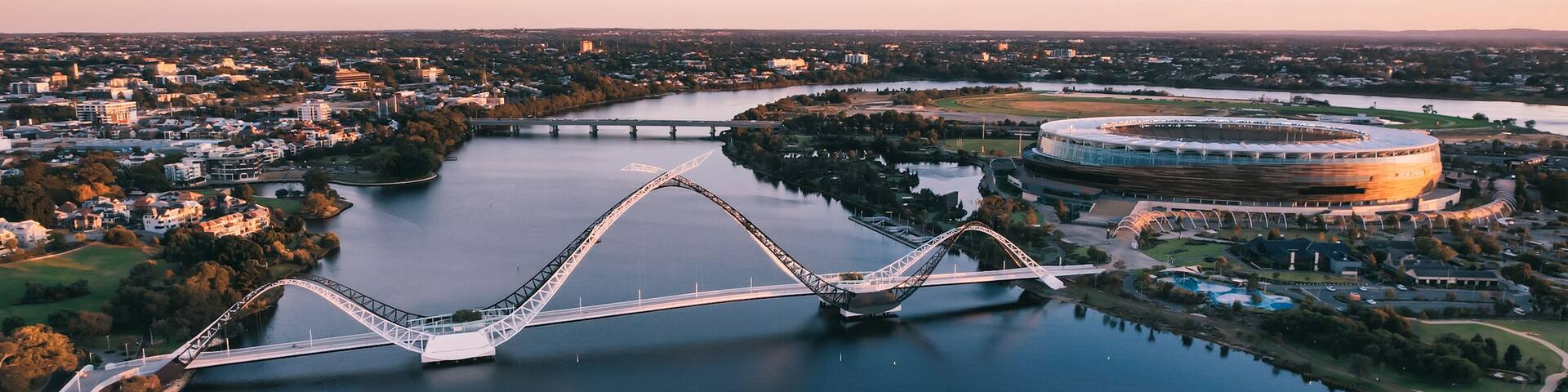 A river with a bridge and a stadium.