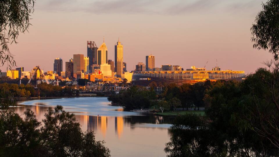 A city skyline with prominent buildings, a river, and a stadium.