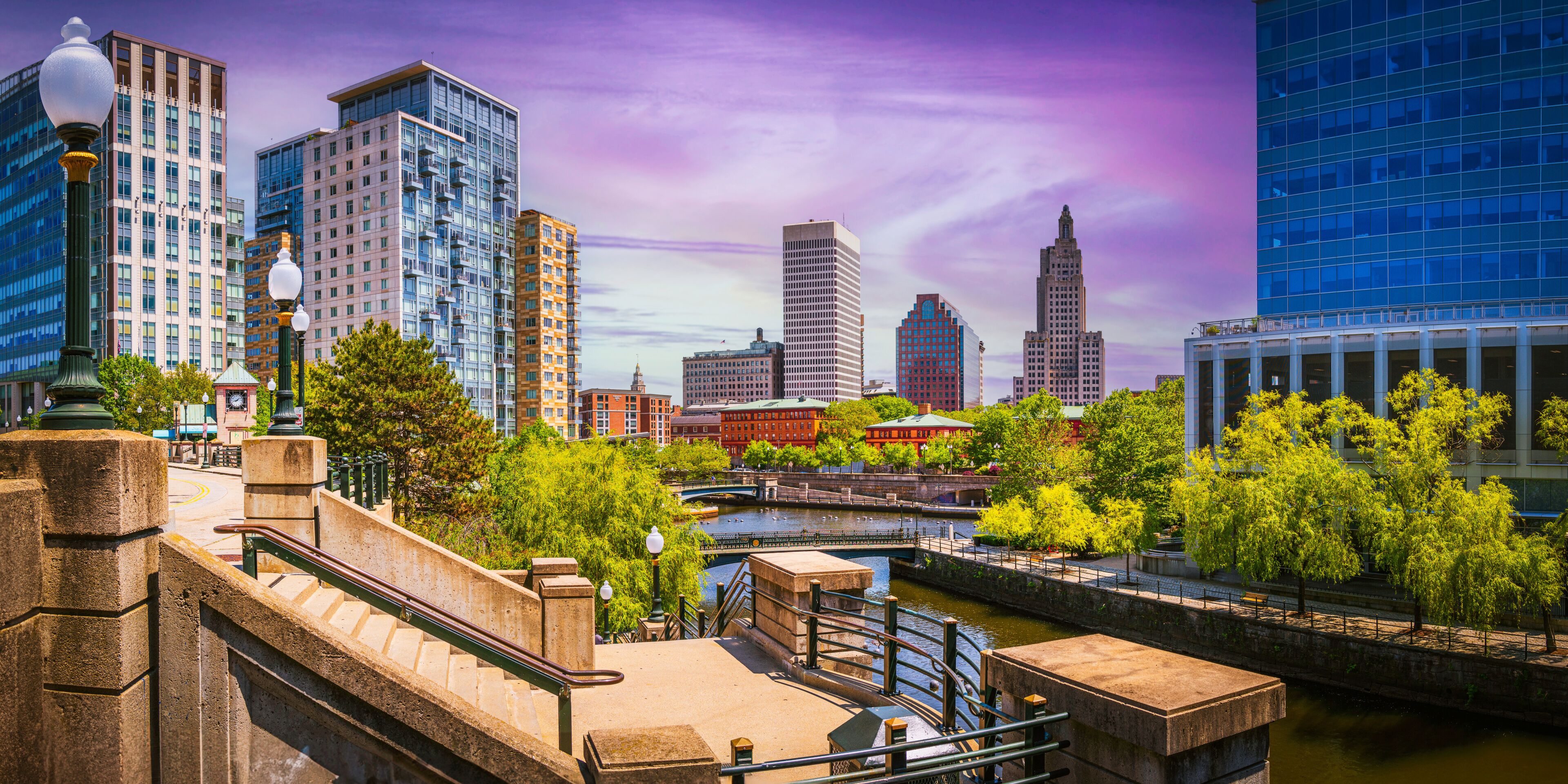 A cityscape with modern buildings, a river, and a bridge.