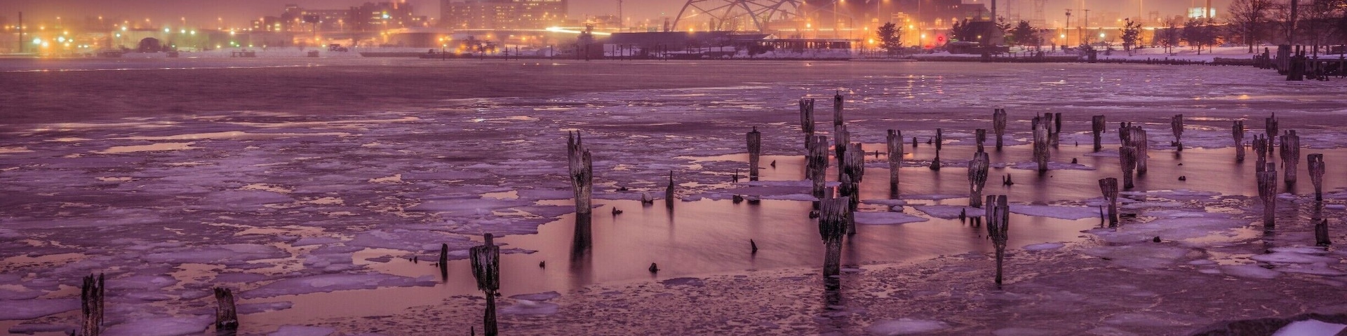 Cutting across town, I saw this view in my rear view mirror. I quickly pulled over, grabbed my camera and tripod, ran to the water's edge and took this photo just before the light changed. The background buildings and sky have such a unique color to them because it just started to snow