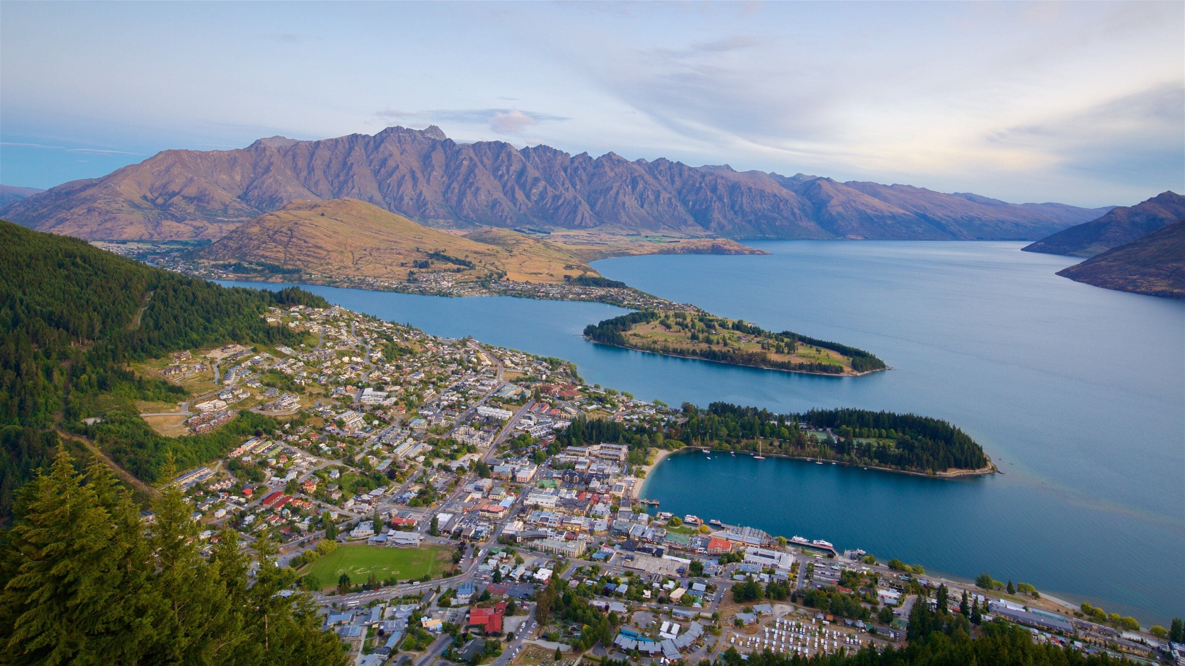 A coastal town with a lake, mountains, and dense forests.