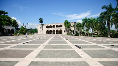 A large open plaza with a historic building featuring arches and a central courtyard.